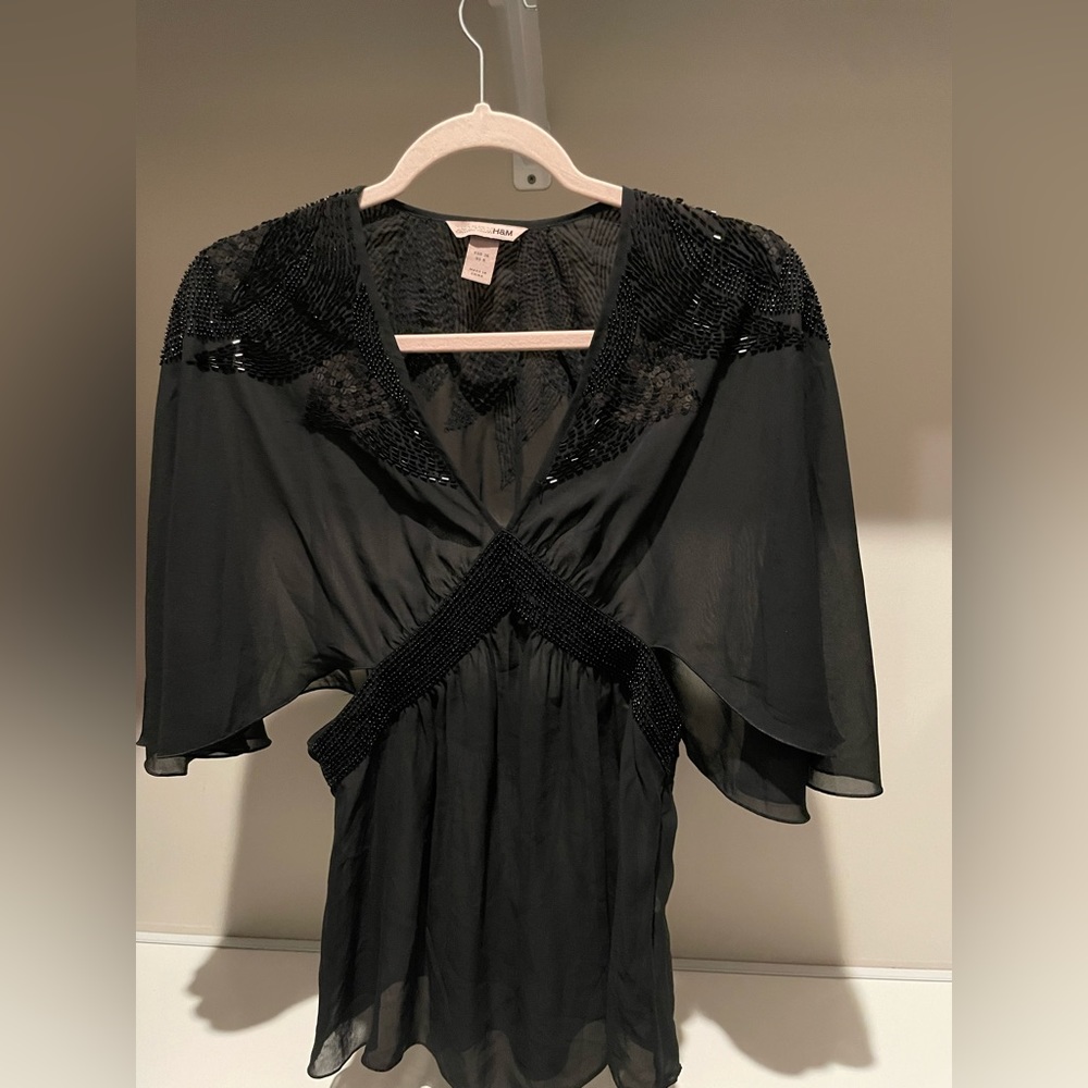 Sequinned chiffon cape blouse with zipper at the side.